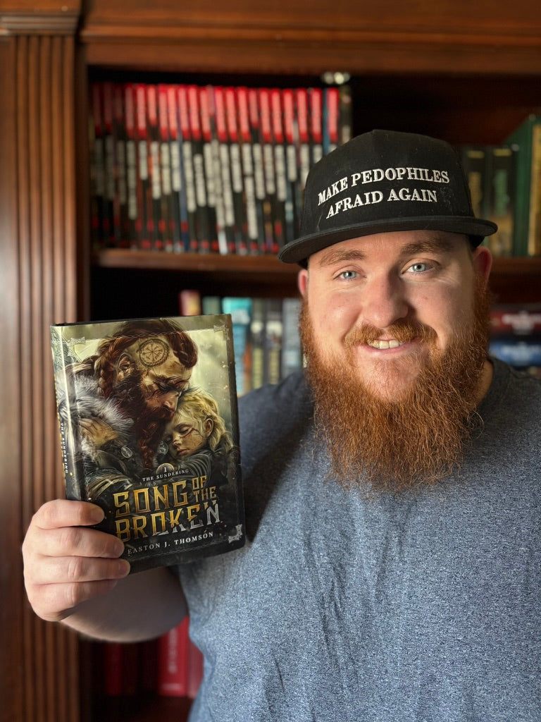 Photo of Easton J. Thomson with a hardcover copy of Song of the Broken: The Sundering