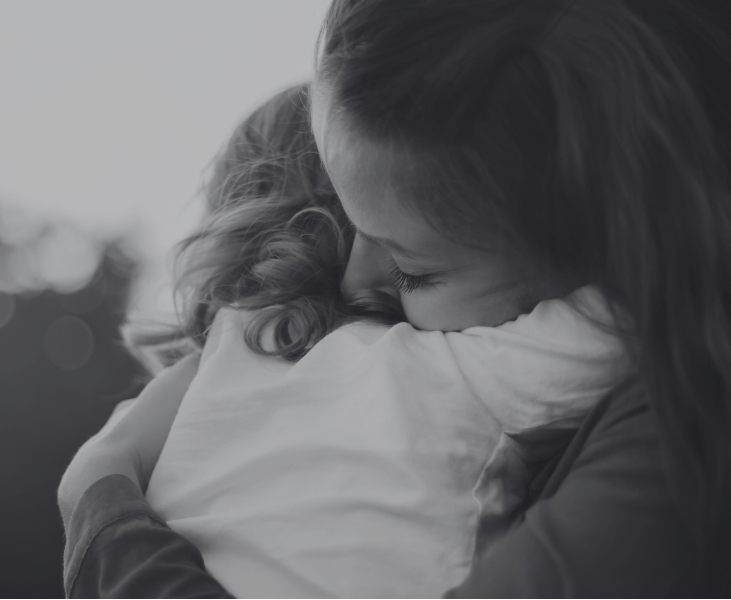 Two people embracing with a blurred natural background