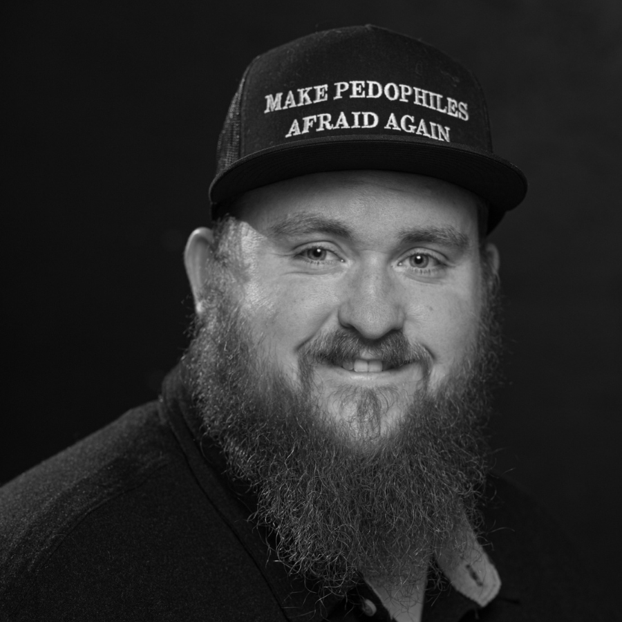 Professional photo of author Easton J. Thomson wearing a hat with the message 'make pedophiles afraid again'.